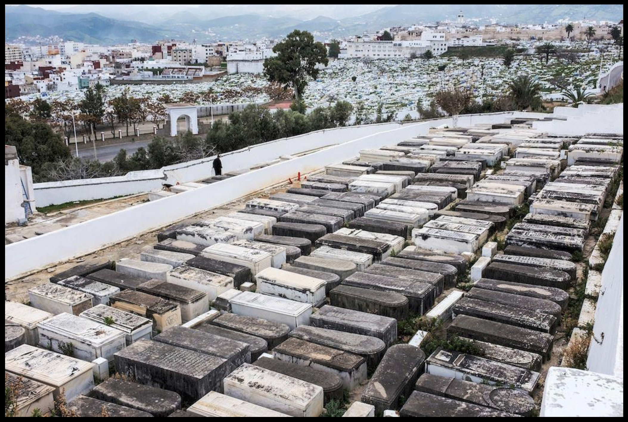 Jewish cemetery in Tetouan, Morocco — rows of white headstones in a well-maintained historic cemetery